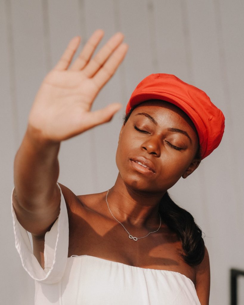 Fed up woman in red cap with raised hand